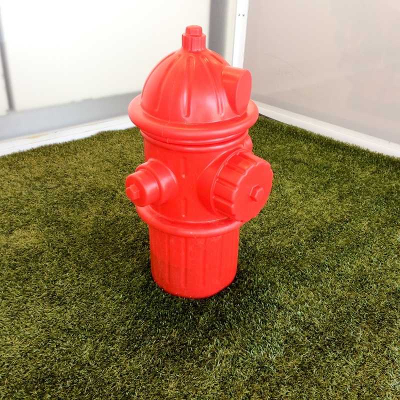 fire hydrant toy for dogs placed on an area of artificial turf